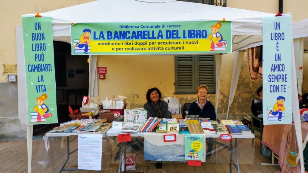 Il gazebo della Bancarella del Libro della Biblioteca Comunale di Ferrere con due volontarie