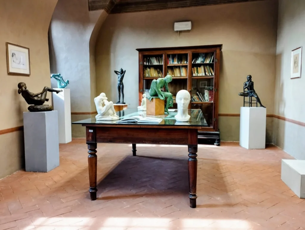 Sculture in bronzo e marmo esposte in una sala con pavimento in cotto del Municipio