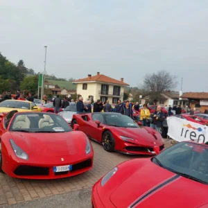 Auto sportive rosse allineate lungo la via durante il raduno supercar