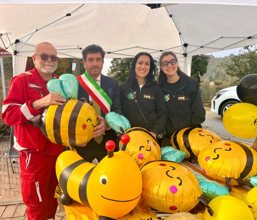Il sindaco con la fascia tricolore e i volontari di Ferrere Miele tra i palloncini a forma di ape