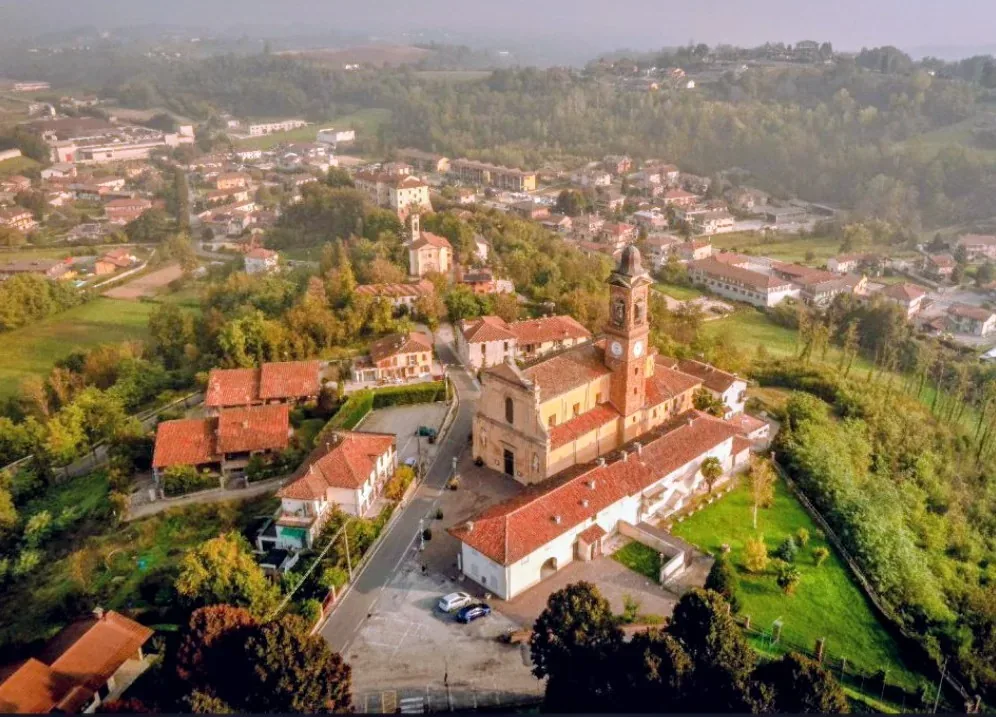 Vista aerea di Ferrere con la chiesa parrocchiale e le case affacciate sulle colline